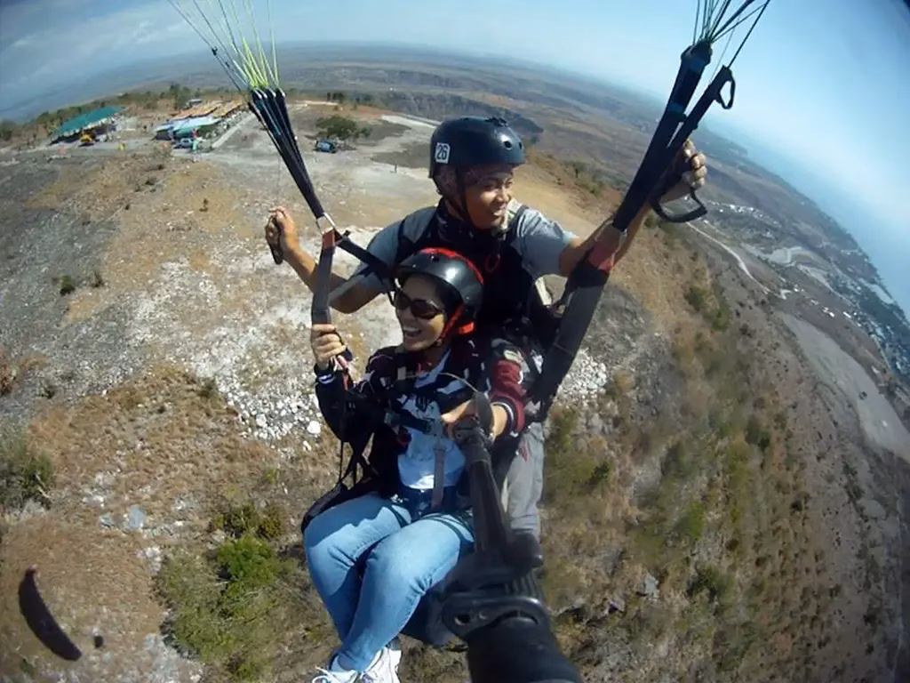 A picture of a couple of people riding a paraglider near Sarangani Bay in the Philippines.