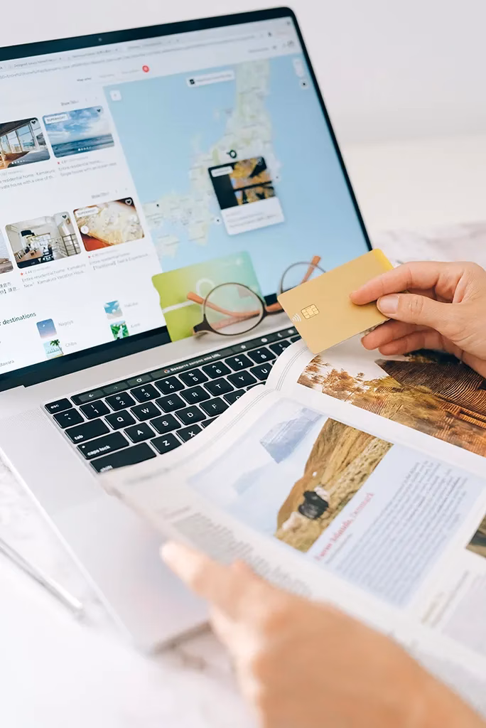 A picture with a laptop and travel tools displayed to assist with scheduling a trip.