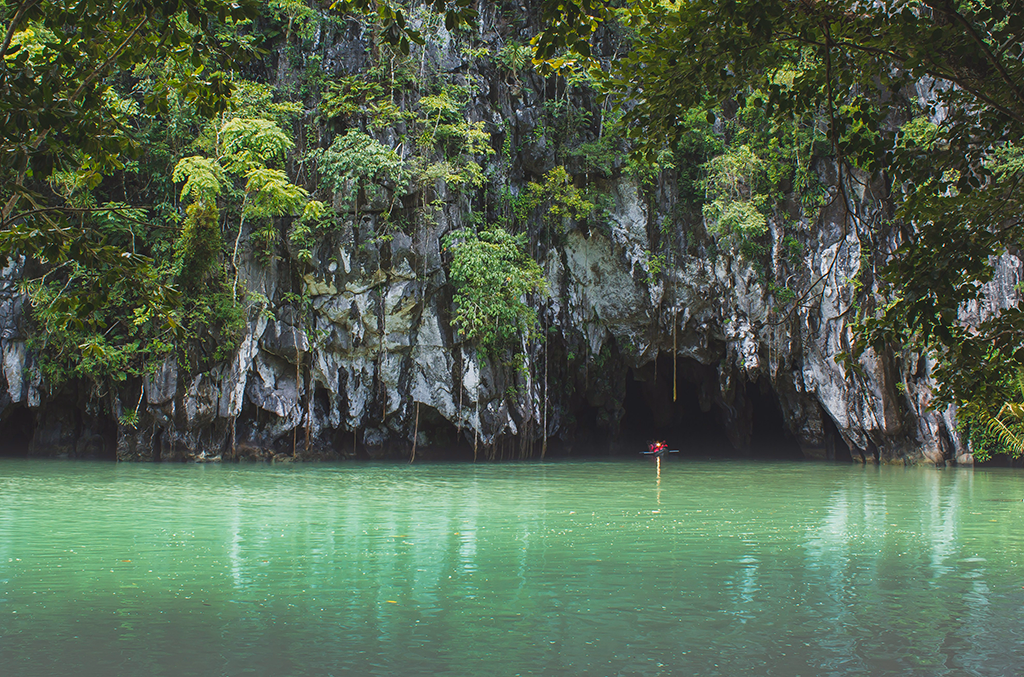 Puerto Princesa Subterranean River National Park Palawan Philippines with limestone cave entrance, green river water, and dense tropical forest.